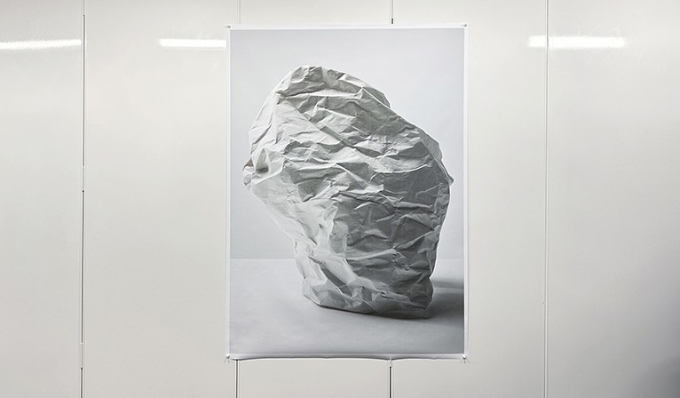 Photographie d'une sculpture suspendue en forme de papier froissé.