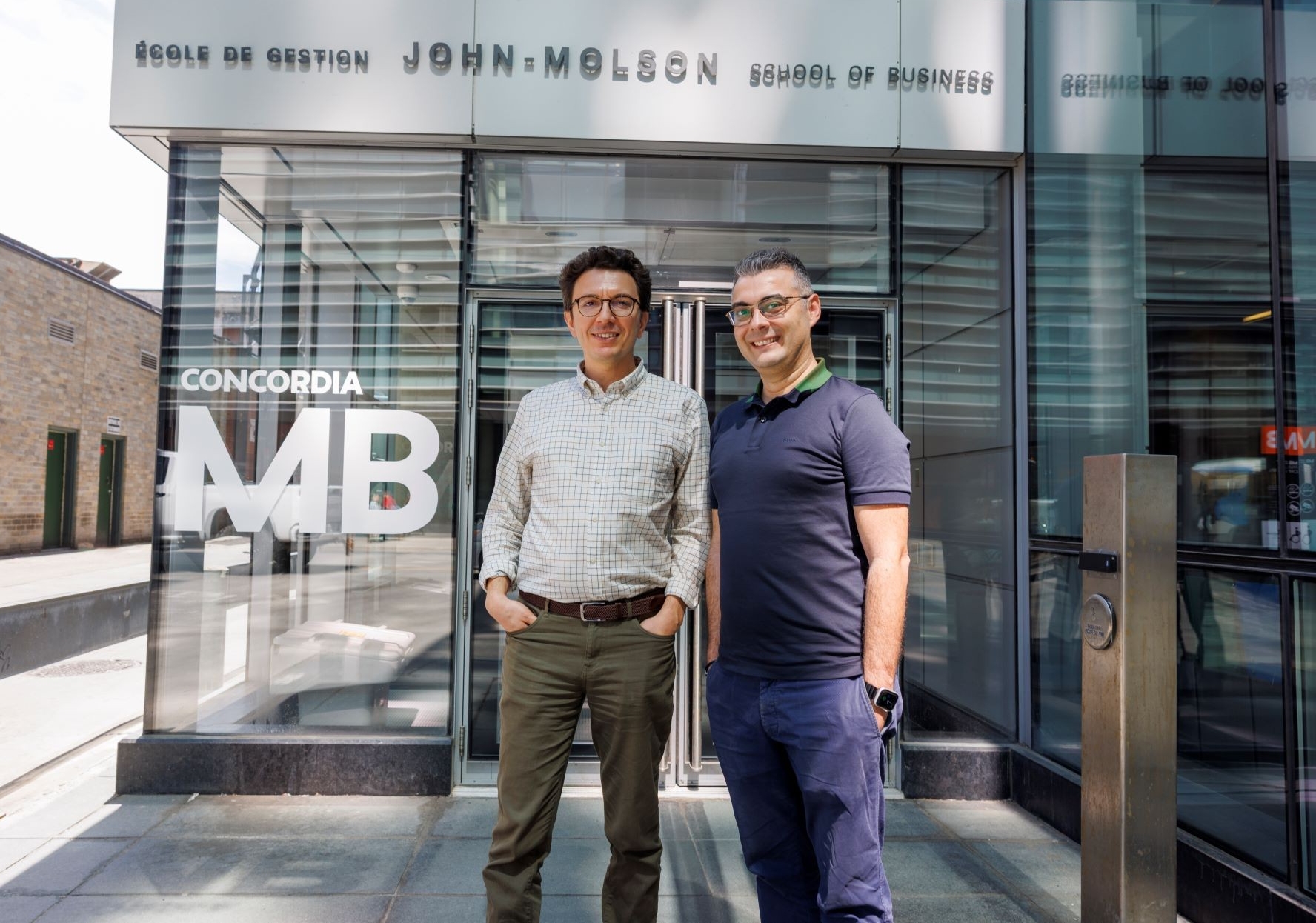 Mehmet Özsoy and Erkan Yonder Two men stand outside the John Molson School of Business