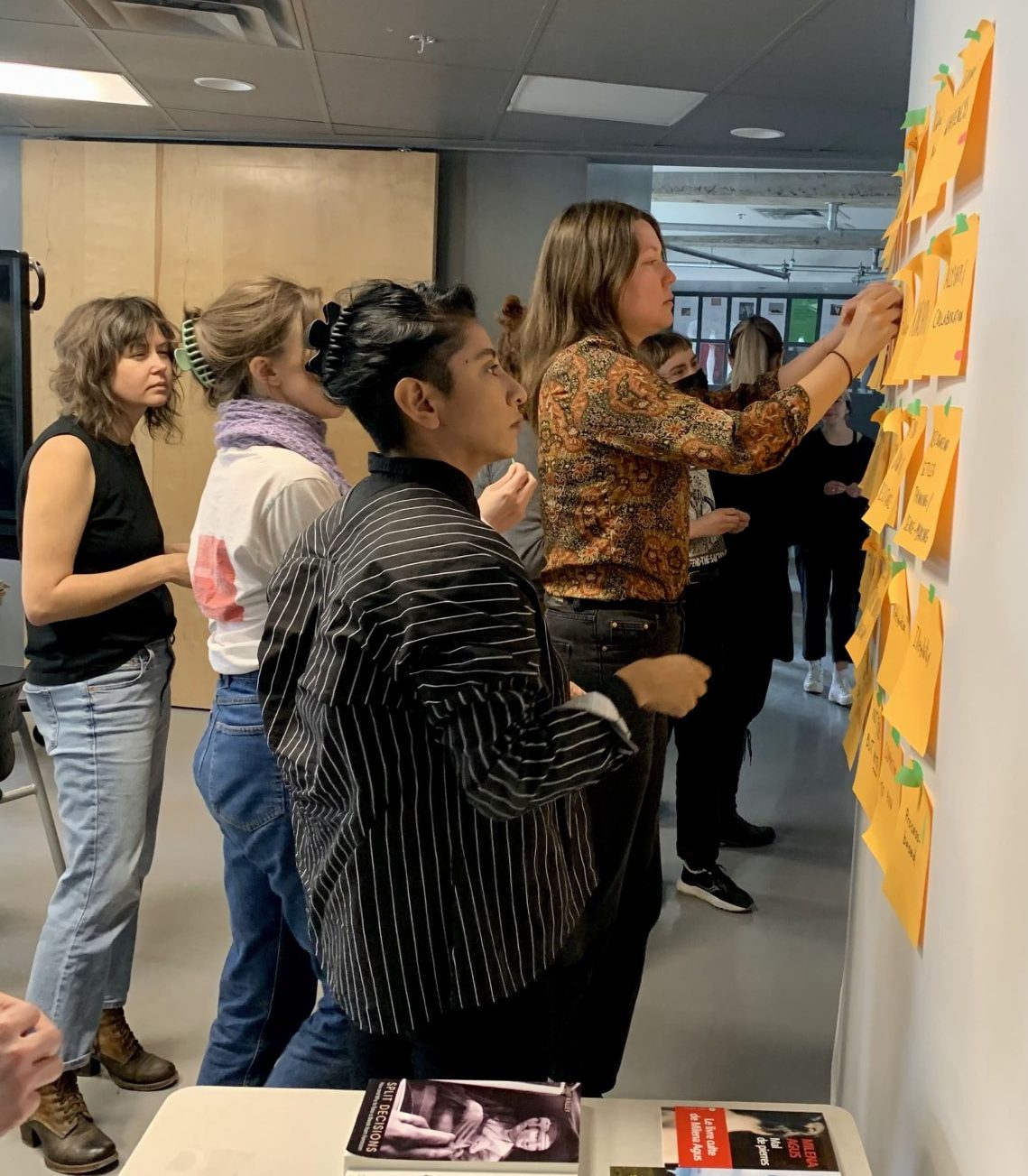 Students are taking part in an interactive session, by working with sticky notes on a classroom wall