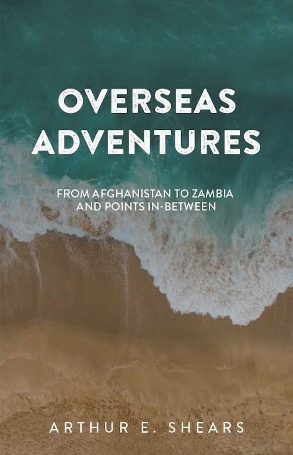 Book cover for 'OVERSEAS ADVENTURES - FROM AFGHANISTAN TO ZAMBIA AND POINTS IN-BETWEEN' by Arthur E. Shears. The cover features an aerial photograph of a shoreline where the deep green sea meets a sandy beach, with waves crashing onto the shore. The title is displayed in large white letters at the top, and the author's name is at the bottom.