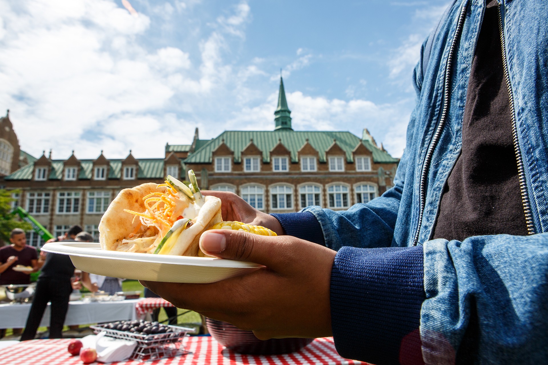 A student holds a taco at a picnic event on the Loyola campus