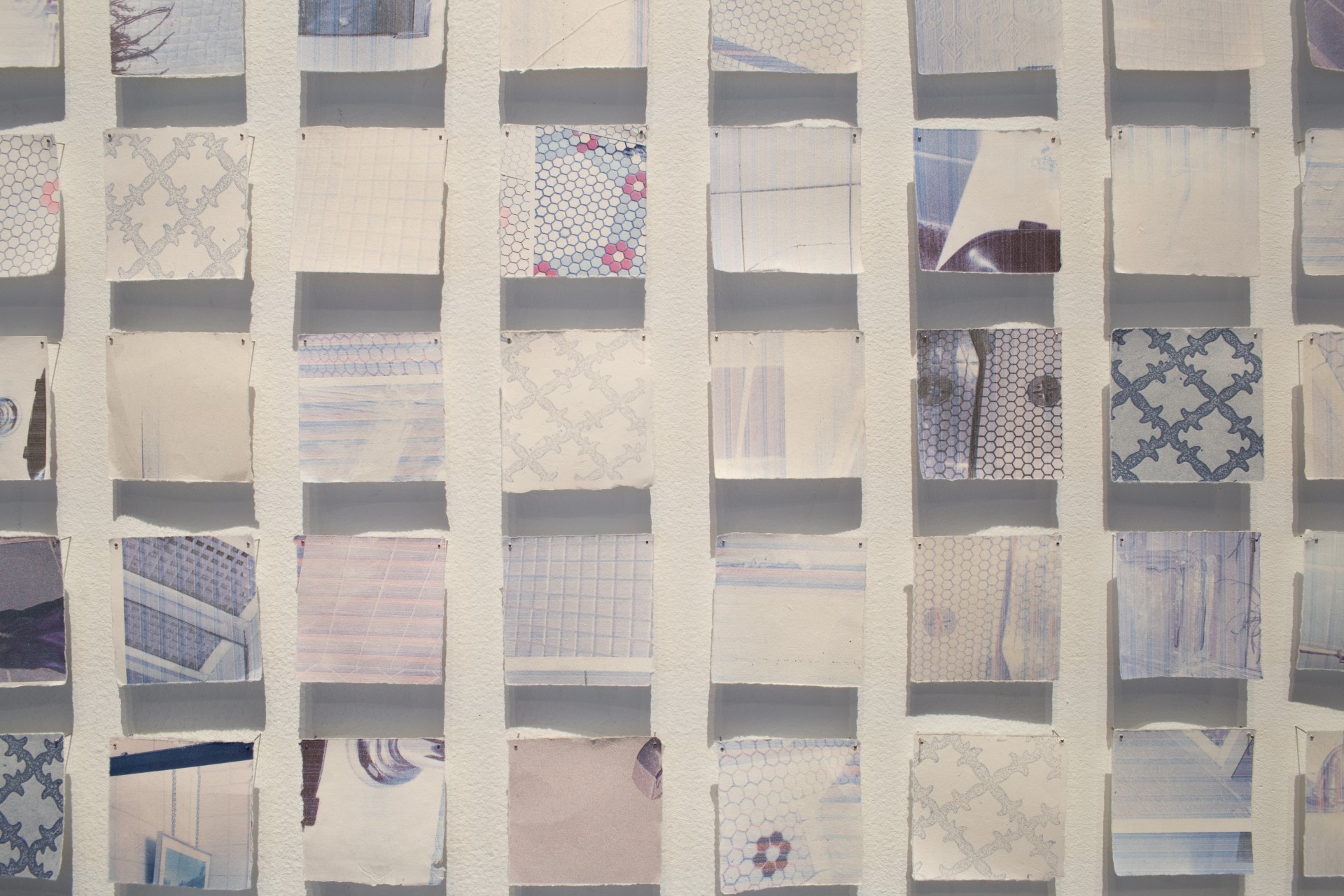 Detailed documentation of the work vestiges de nos déshabillements. This photo features a grid of photographed bathroom tiles printed on paper made out of toilet paper. 