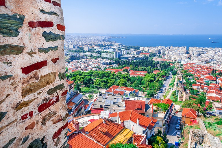 Aerial shot of colourful houses and roofs in a city on the sea.