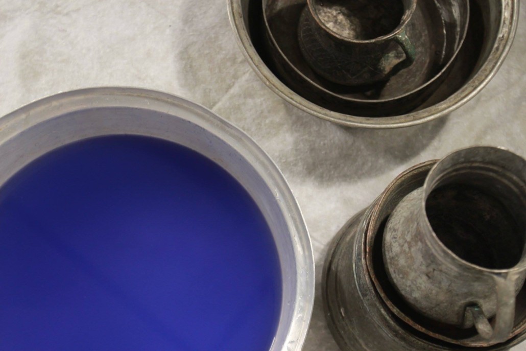 Overhead shot of blue and black paint pots. 