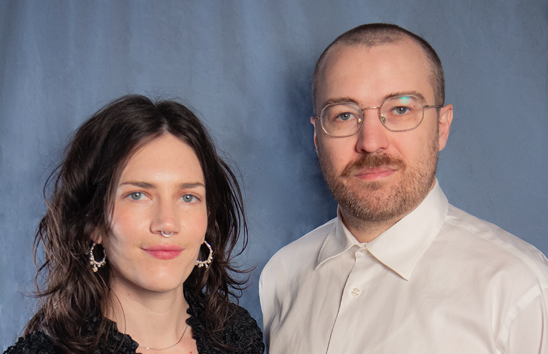 A portrait of a dark-haired woman and a man with short hair wearing glasses