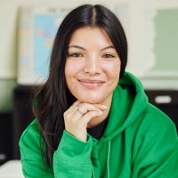woman with long, dark hair, wearing a bright green hoodie