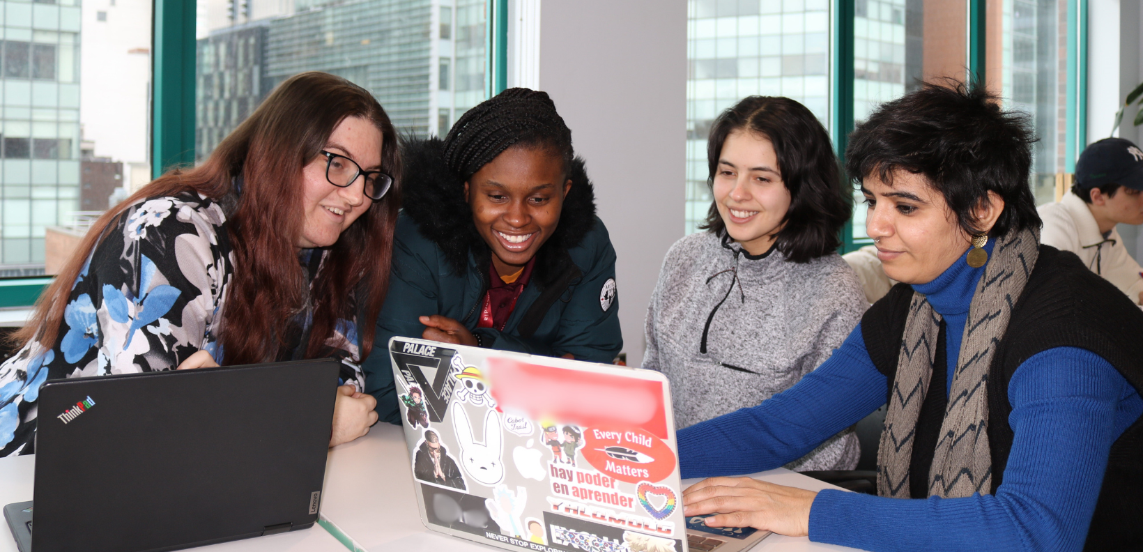 4 students looking at a computer together