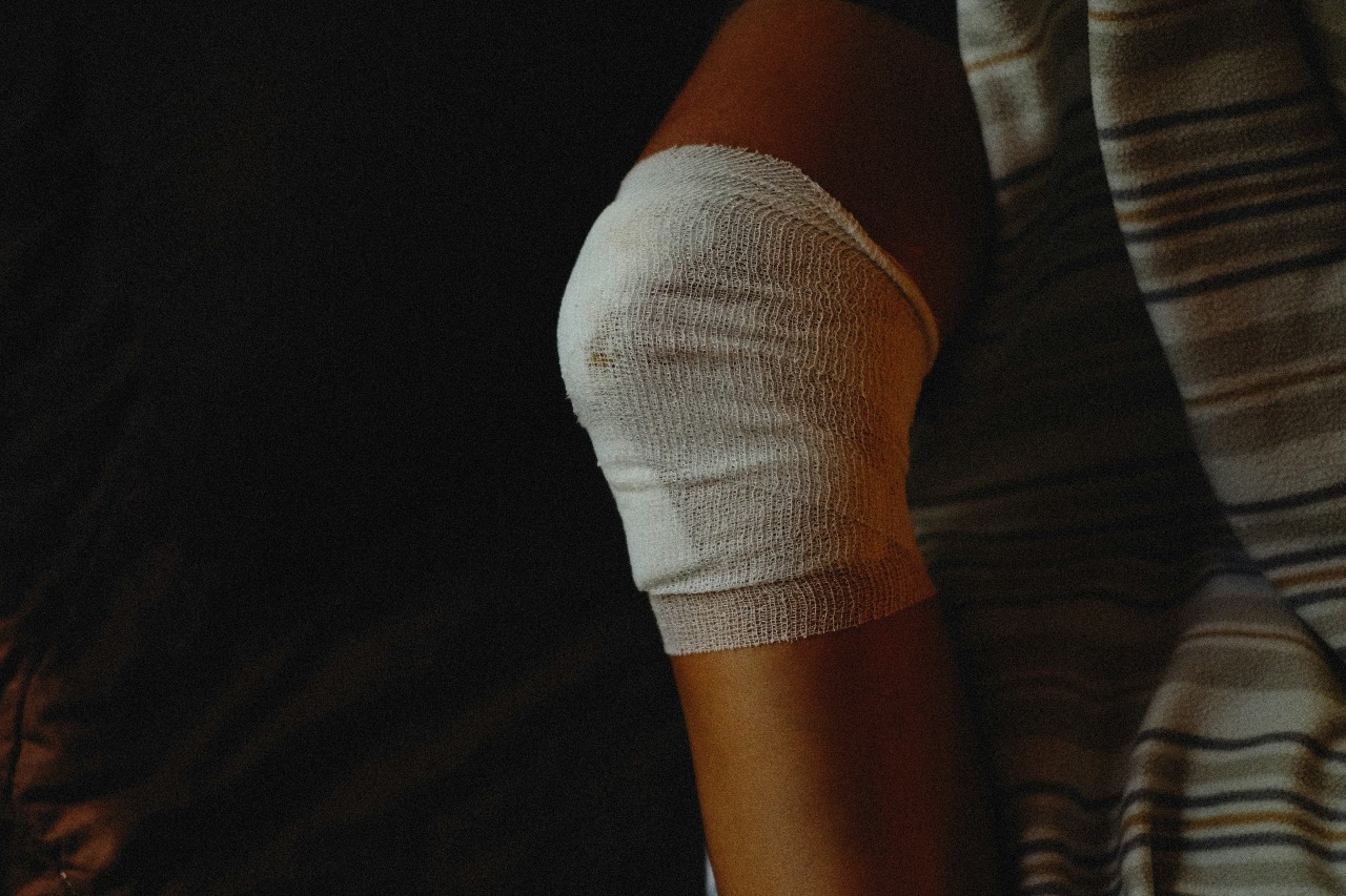 A person wearing a striped shirt with bandage on elbow