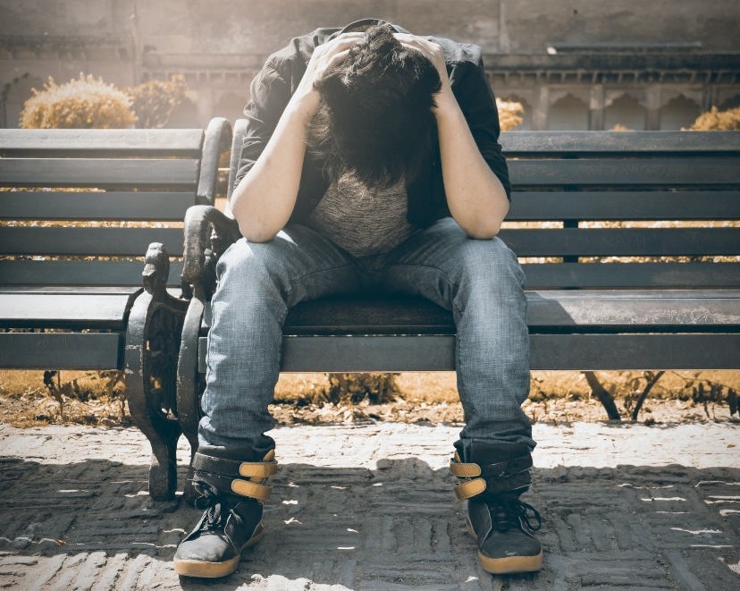 person sitting on bench distressed. 