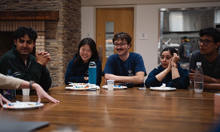 A group of young people seating at a long table