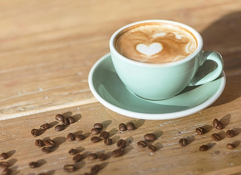 a cappuccino in a brown mug on a wooden table