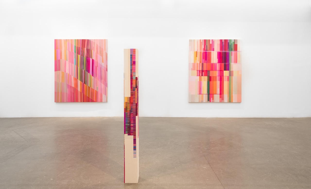 multicolored geometric paintings displayed in an art gallery