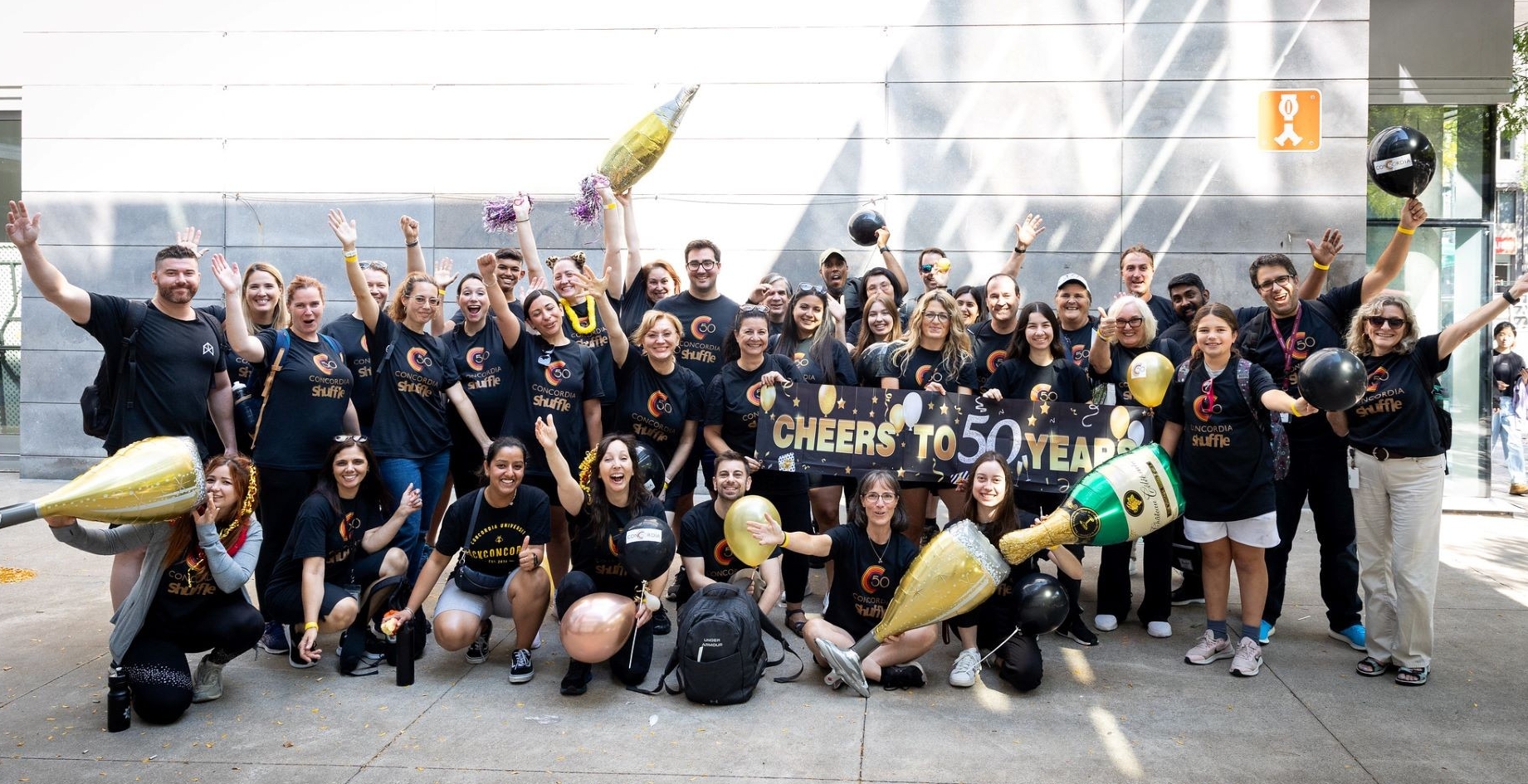 Group of Shufflers pose with balloons and props in celebration of the university's 50th anniversary.