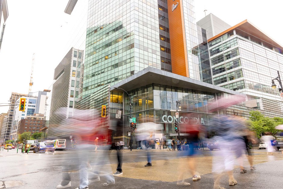 A view of the corner of St-Catherine and Guy streets with pedestrians walking by.