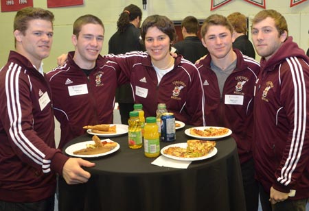 Stingers wrestler David Tremblay (left) and former Stingers wrestler and alumnus Martine Dugrenier (centre), who both competed at the 2012 Summer Olympics in London, with members of the Stingers wrestling team