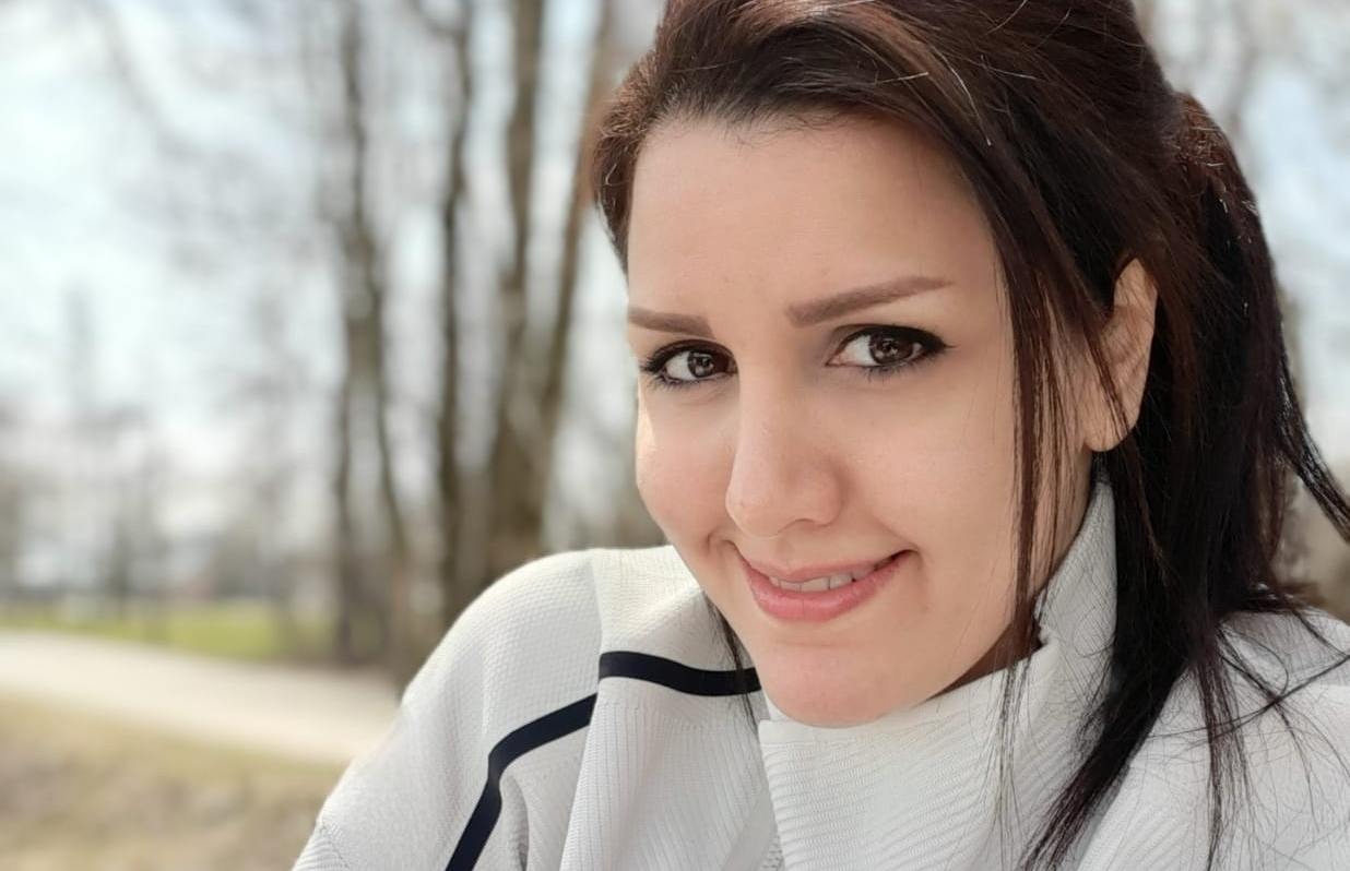 Maryam Sharifi Rad porte un pull blanc et sourit
