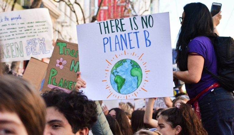 Climate protesters holding signs urging for urgent climate action