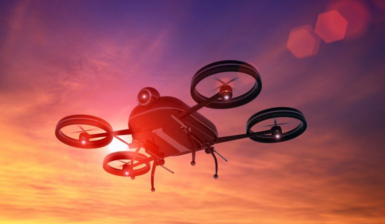 Futuristic looking drone or aeroplane flying in the sky at sunset