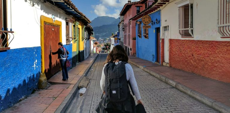 A school age girl walks down a street in Bogota, Colombia