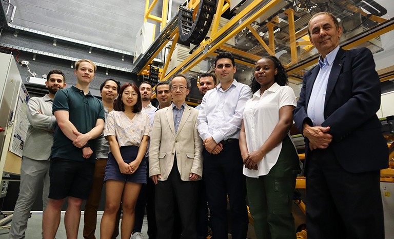 A group of diverse people standing in a lab and looking down at the camera