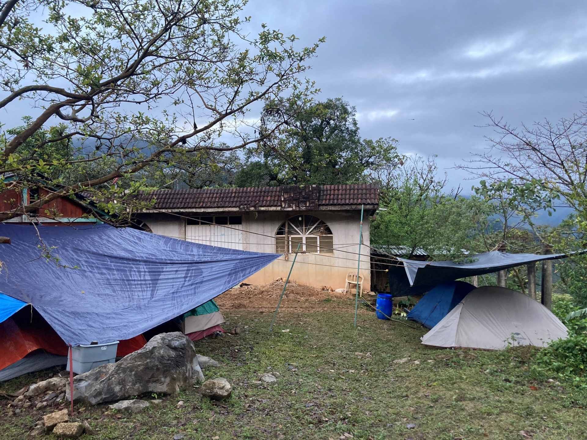 Tents and tarp and an old hut under a cloudy sky in Mexico