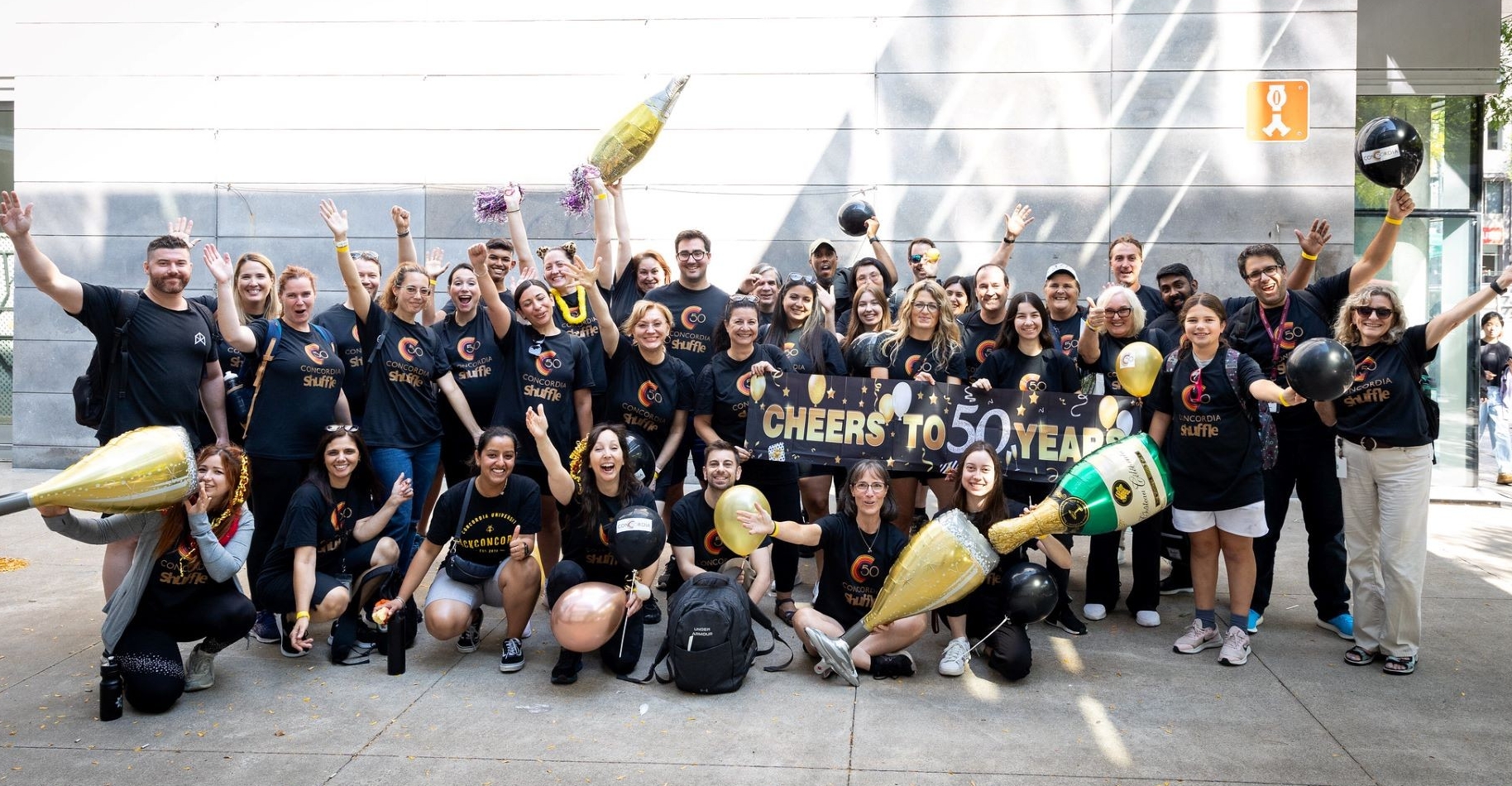 Un groupe de Shufflers pose avec des ballons et des accessoires pour célébrer le 50e anniversaire de l'université.