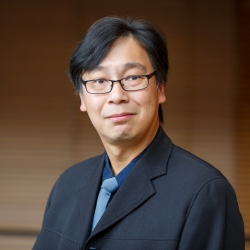 Portrait de Hoi Dick Ng, professeur à l'École de génie et d'informatique Gina-Cody de l'Université Concordia, portant des lunettes et un costume sombre."